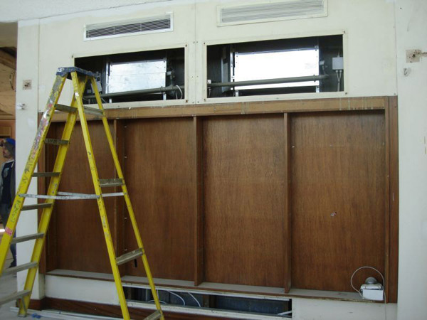 Ladder positioned beside custom shelving installation with cut-outs for ventilation at Fullwell Cross Library