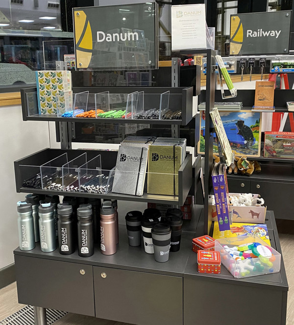 Display of merchandise including water bottles, notebooks, and stationery items in a retail unit at Danum Gallery Library Museum – Shop