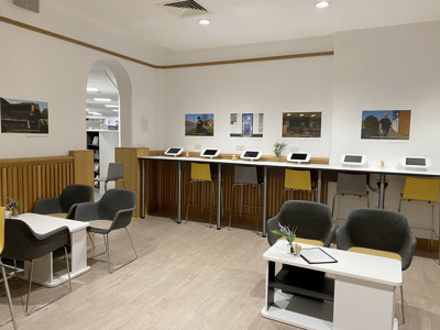 Modern grey lounge chairs and yellow bar stools at a study area with tablet stations at Danum Library