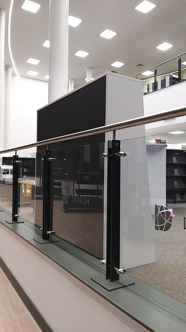 Transparent glass panels and sleek black kiosk housing overlooking the open-plan library floor at Danum Library