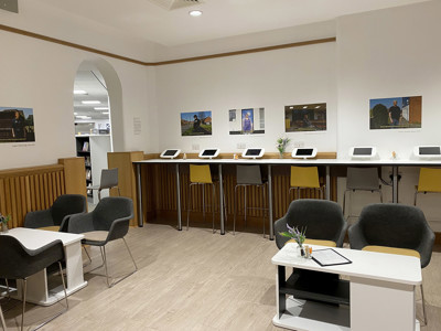 High-backed grey chairs and yellow stools at a digital study area with touchscreen devices at Danum Library