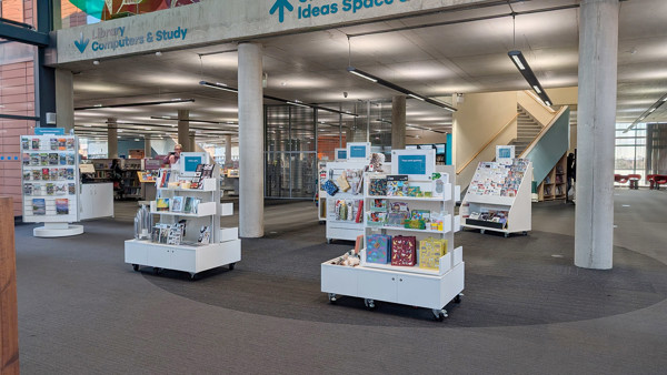 Mobile display units filled with books and products in a public library browsing area at Oldham Library & Gallery Shop – mobile units