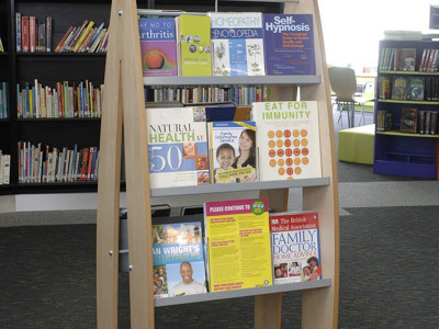 Wooden display stand featuring health and wellbeing books in a browsing area at Yate Library