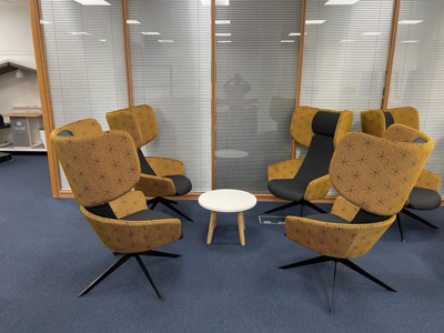 Patterned yellow and black lounge chairs arranged around a white coffee table in a collaborative work area at Shoreditch Library