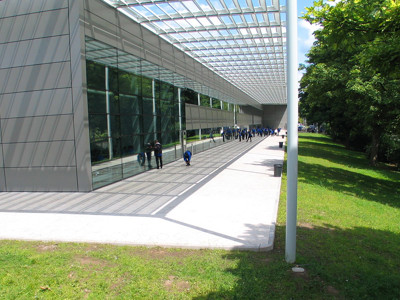 Large glass windows and a modern exterior with a shaded walkway at Djanogly City Academy