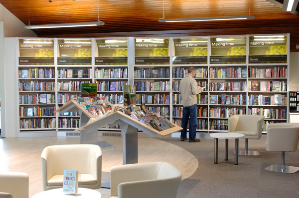 A patron browsing novels at face-out book displays in a public library browsing area at New Ash Green Library