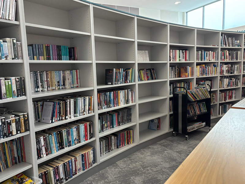 Deep storage shelving behind lightbox wall