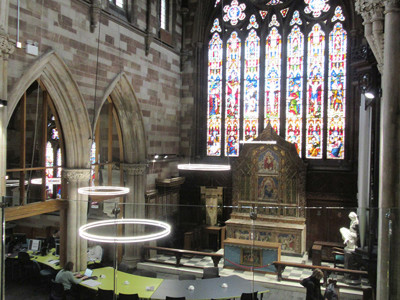 Stained glass windows and modern study tables in a spacious reading area at Lichfield Library