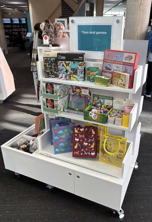 Colourful display unit filled with toys and games, featuring puzzles and craft items at Oldham Library & Gallery Shop – more toys and games