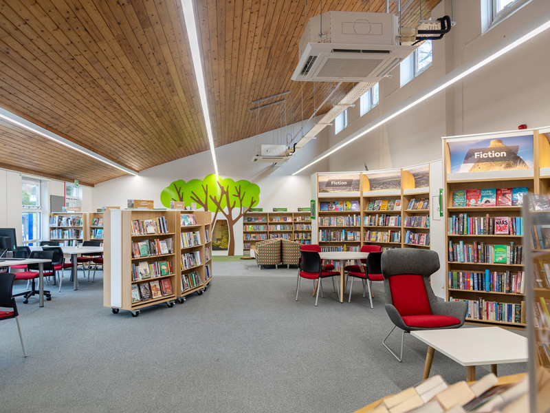 Small library interior design — compact community library space planning with warm wood ceiling