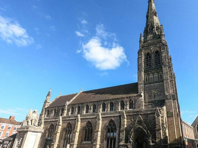 Historic stone architecture with a tall spire and intricate gothic windows at Lichfield Library