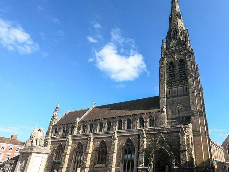 Historic stone architecture with a tall spire and intricate gothic windows at Lichfield Library