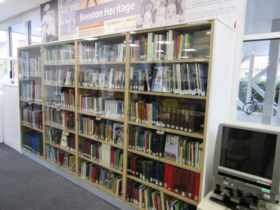 Tall shelving units filled with neatly arranged books and archival materials in the local studies area at Beeston Local Studies