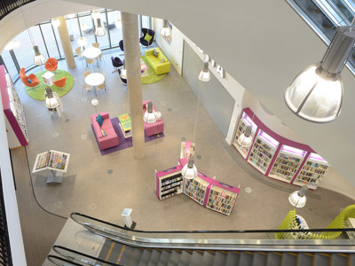 Curved shelving units and colourful seating areas create a vibrant browsing space at Southwater Library