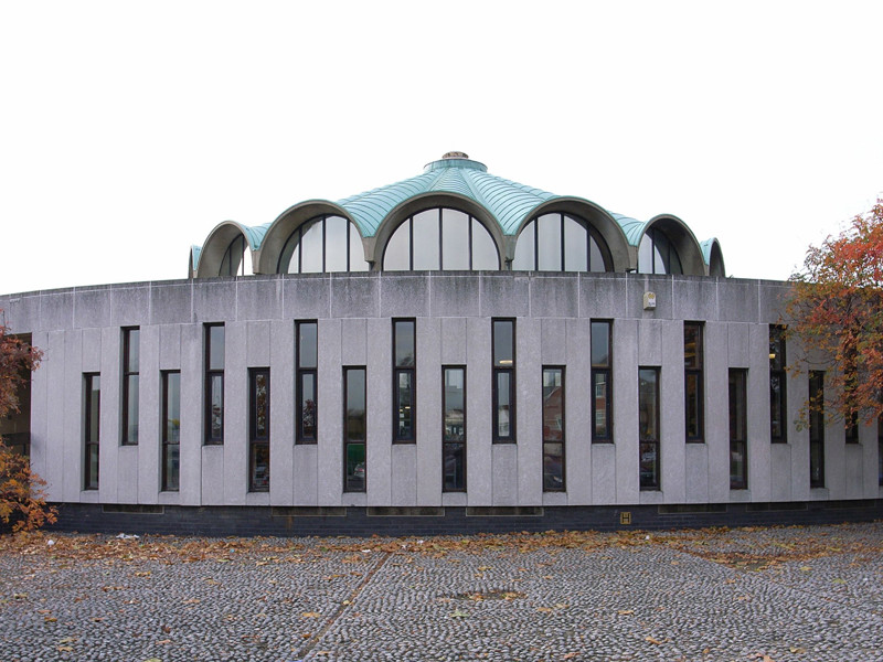 Curved stone façade with large arched windows and a distinctive domed roof at Fullwell Cross Library