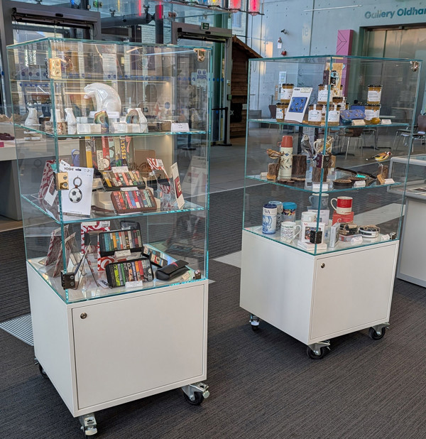 Glass display cabinets filled with various merchandise at Oldham Library & Gallery Shop – mobile cabinets with storage