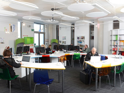 Colourful chairs around collaborative work tables in a study area at Stafford Innovation Suite
