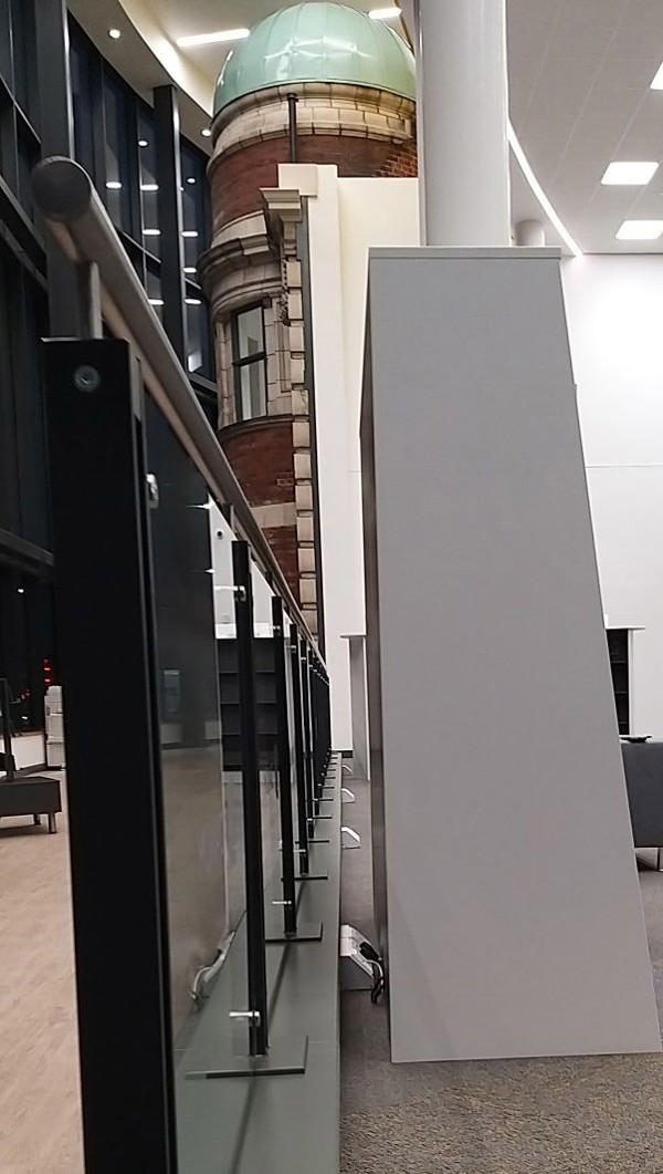 Sleek grey shelving units alongside a glass barrier in a modern library interior at Danum Library