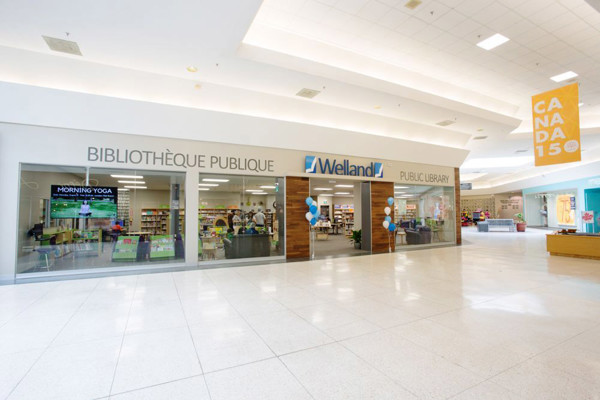 Glass storefront with colourful signage and balloons at the entrance of the public library at Seaway Mall Branch, Welland Public Library, Ontario