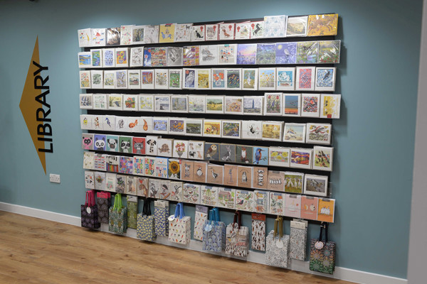 Colourful greeting cards and tote bags displayed on a wall at the retail area at Gateshead Library