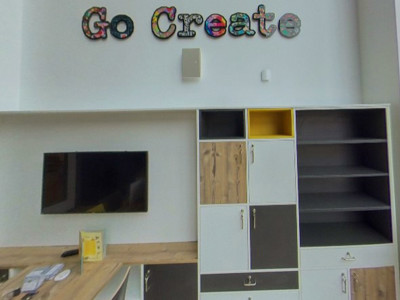 Custom storage units with grey and yellow accents and a 'Go Create' sign in a makerspace at Danum Library