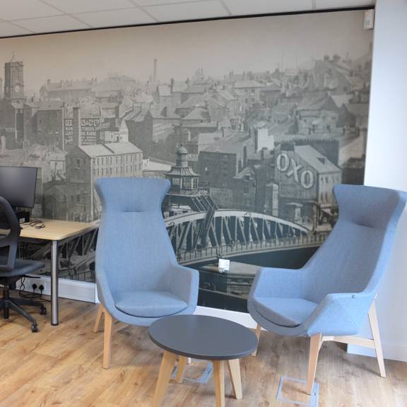Early archive photo of Gateshead used as wall graphic behind PC desks and seating area
