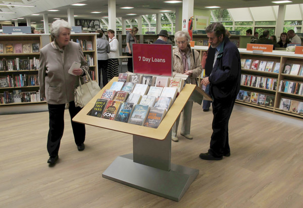 A display table featuring a selection of books labelled "7 Day Loans" in a public library browsing area at Newark Library