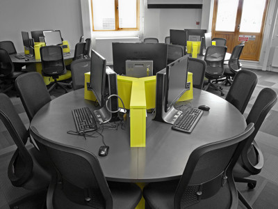 Circular study tables with bright yellow dividers and computer stations at Boots Library