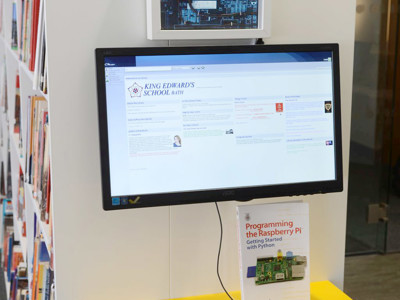 Bright yellow study table with a computer setup and a book on programming at King Edward's School