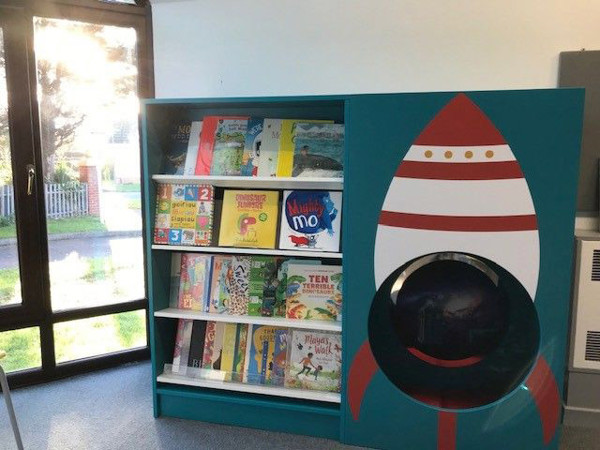 Rocket-themed book display with face-out titles in a children's reading area at Kinmel Bay Library