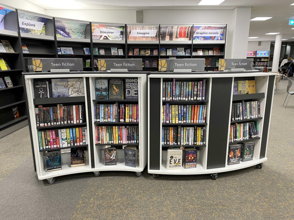 Curved mobile shelving units displaying a range of teen fiction titles at Danum Library