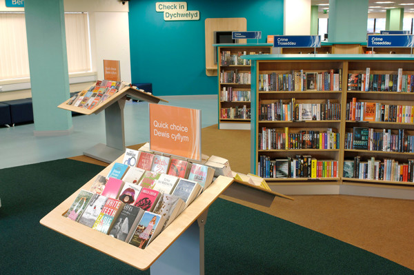 Face-out book displays and browsing shelves in a bright public library browsing area at Swansea Library