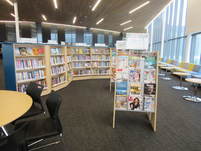 Magazine display stand and browsing shelves in a public library browsing area at Sherwood Library