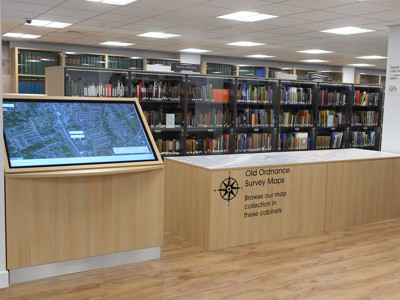 Interactive touchscreen display and wooden map cabinets in a local studies area at Gateshead Archive