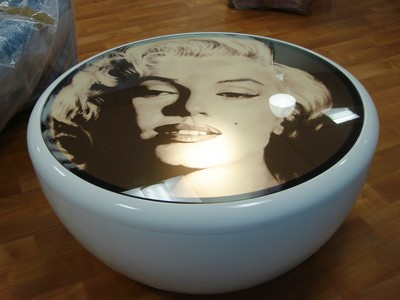 Glossy round table featuring a Marilyn Monroe image in a study area at Risca Palace Library