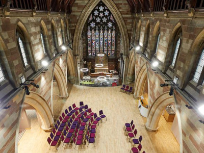 Circular arrangement of purple chairs on a wooden floor beneath a high vaulted ceiling at Lichfield Library