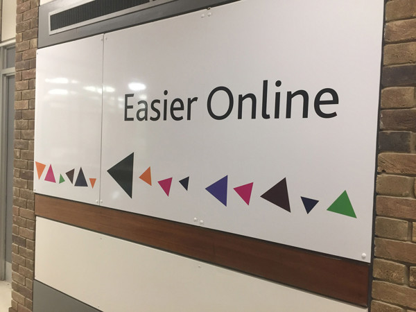 Bold signage with geometric shapes in purple, green, and orange directing visitors at County Library Oxfordshire – wayfinding