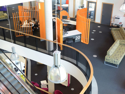 Curved orange partitions and patterned seating create distinct zones in the open-plan library floor at Southwater Library