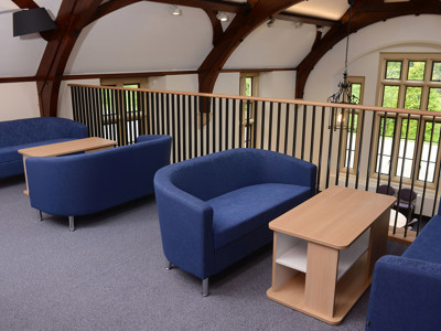 Blue upholstered sofas and a light wood coffee table in a study area at Kingham Hill School