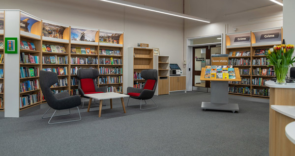 Grey and red lounge chairs beside a quick choice display and browsing shelves at Chinnor Library