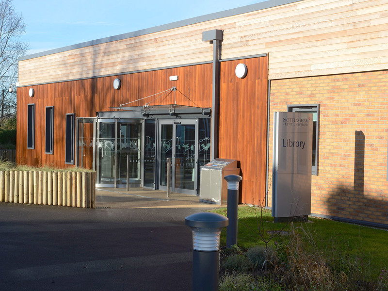 Wooden cladding and large glass doors at the entrance of Brackenhurst Campus Library, featuring a modern design at Brackenhurst Campus Library
