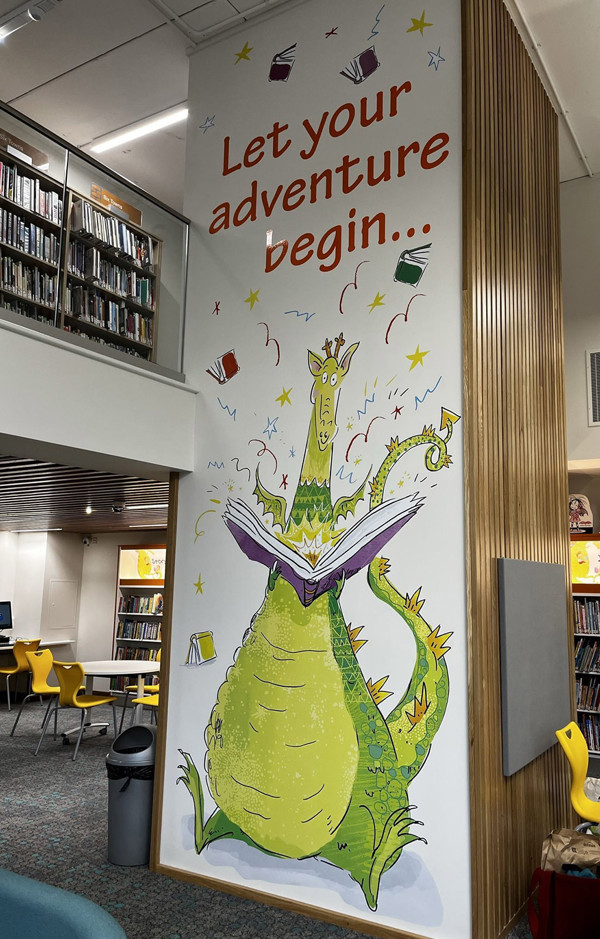 Colourful dragon mural with an open book and playful text in a children's reading area at Stoke City Central Library