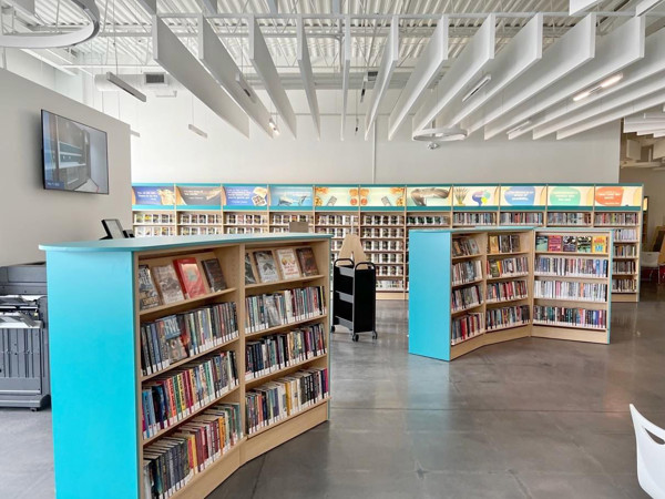 Curved shelving units with colourful book displays in a browsing area at Holly Branch, Barrie Public Library, Ontario