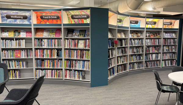 Curved shelving units displaying a diverse range of books in the browsing area at Sale Library