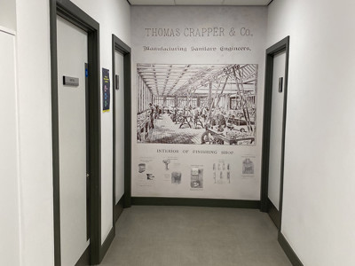 Illustrative wall mural depicting a historic manufacturing scene at a corridor in Danum Library