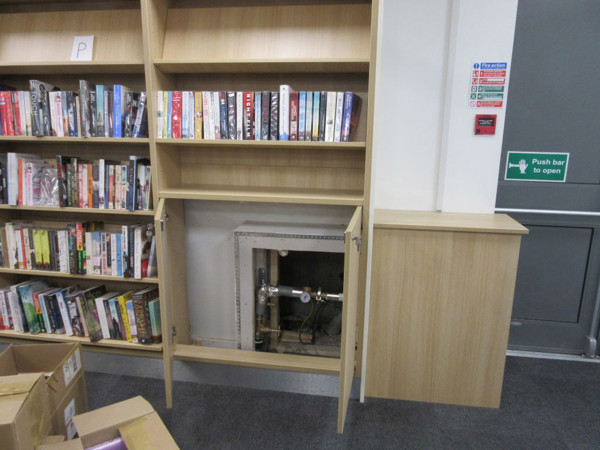 Custom shelving unit with access to heating pipes integrated into the design at Arnold Library