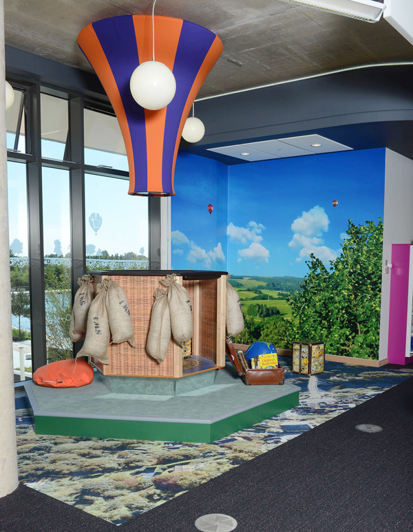 Brightly coloured hot air balloon feature above a playful reading nook with bean bags and book displays at Southwater Library