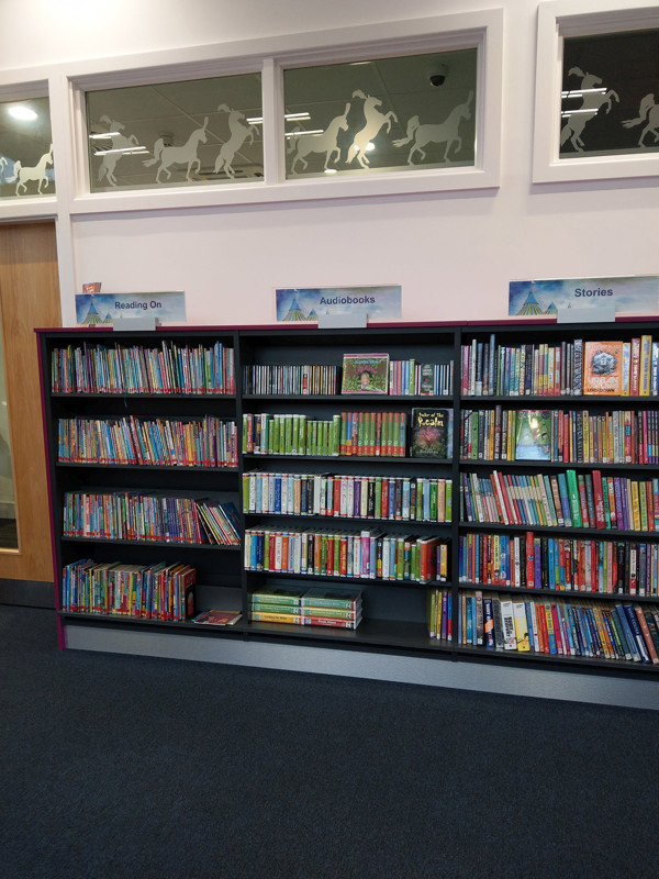 Colourful browsing shelves filled with children's books and audiobooks in a themed book display at Newcastle Under Lyme Library