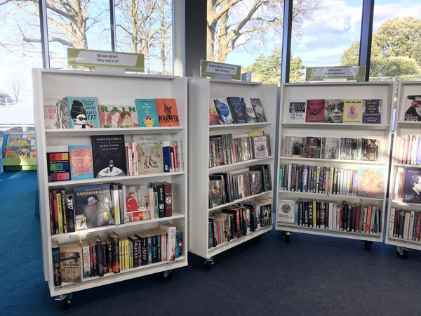 Colourful face-out book displays featuring a variety of titles in a public library browsing area at Conwy Culture Centre