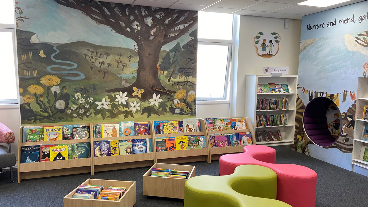 Colourful pink and green seating alongside face-out book displays in a children's reading area at Blaydon Library